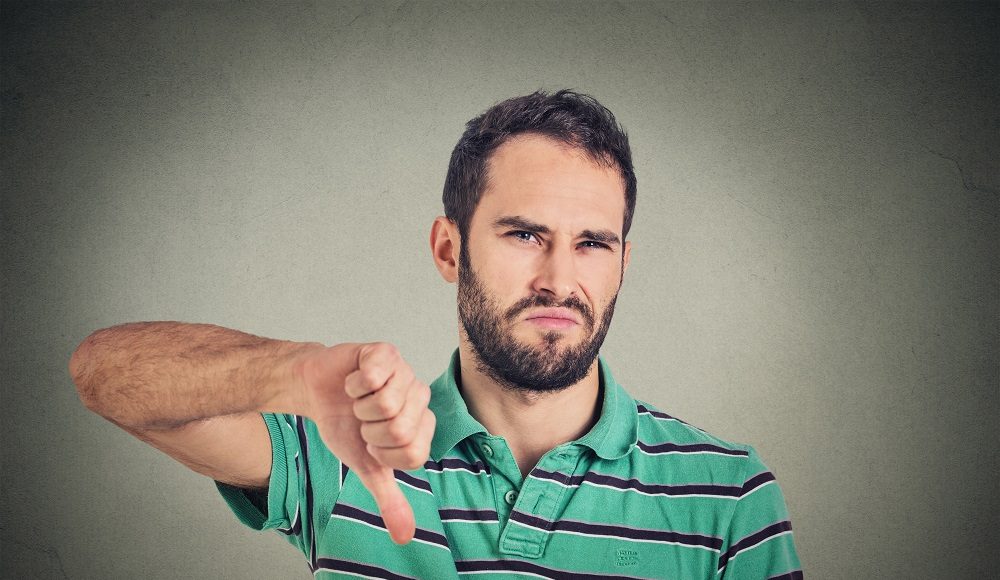 Closeup,Portrait,Angry,,Unhappy,,Young,Man,Showing,Thumbs,Down,Sign,