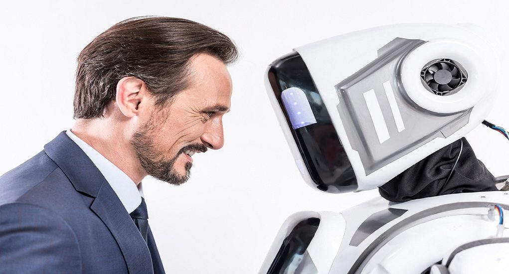 Cheerful,Smiling,Male,Person,Looking,At,Robot